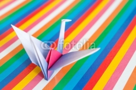 Obrazy i plakaty An origami bird on a colorful stripes background.